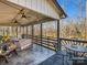 Covered back porch featuring comfortable seating, ceiling fans, and a view of the surrounding woods at 108 Three Oaks Ln, Kings Mountain, NC 28086