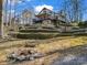 Backyard view with a fire pit, a bench, trees and landscaped hardscaping at 108 Three Oaks Ln, Kings Mountain, NC 28086