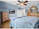 Bedroom with wood floors, TV, ceiling fan, and a dresser with a round mirror at 108 Three Oaks Ln, Kings Mountain, NC 28086