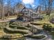 Charming home with a wrap-around deck, lush landscaping, and a stone pathway leading through the terraced front yard at 108 Three Oaks Ln, Kings Mountain, NC 28086