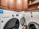 Laundry room features white washer and dryer, wooden cabinets, and tile flooring at 108 Three Oaks Ln, Kings Mountain, NC 28086