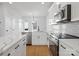 Modern kitchen with white cabinets, gray tile backsplash, and stainless steel appliances at 1122 Pegram Crossing Dr, Charlotte, NC 28205