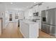 Modern kitchen with white cabinets, island, and stainless steel appliances at 1122 Pegram Crossing Dr, Charlotte, NC 28205