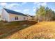 View of a large, grassy backyard with mature trees and a concrete patio off the back of the house at 1135 Rudder Cir, Salisbury, NC 28146