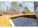 A large concrete patio in a backyard with grass and mature trees in the background at 1135 Rudder Cir, Salisbury, NC 28146