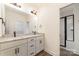 Bathroom featuring double sink vanity with granite countertop, framed mirror, and a tiled shower at 1135 Rudder Cir, Salisbury, NC 28146