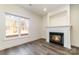 Bright living room with wood-look floors, cozy fireplace, and natural light from the large window at 1135 Rudder Cir, Salisbury, NC 28146