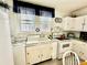 White kitchen with a farmhouse sink, updated appliances, and lace curtains at 12 Maple St, Great Falls, SC 29055