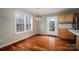 Dining room with hardwood floors, large window, and modern light fixture adjacent to the kitchen at 122 Ardmore Pl, Mooresville, NC 28117