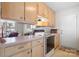 Kitchen with light wood cabinets, a stove, and a pass-through to the dining area at 125 1St N Ave, Conover, NC 28613