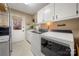 White cabinets and a side door access in this well-lit laundry room at 1360 Hopewell Church Rd, Catawba, NC 28609