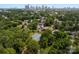 Aerial view showcasing a neighborhood with green trees, tennis court, and the Charlotte skyline at 1912 St John St, Charlotte, NC 28216