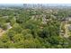 Aerial view of a suburban neighborhood with lush green trees and Charlotte skyline in the background at 1912 St John St, Charlotte, NC 28216