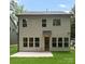 View of the back exterior of the two-story house with a concrete patio and well-manicured lawn at 1912 St John St, Charlotte, NC 28216
