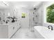 Bright bathroom features a freestanding tub, glass-enclosed shower, and double vanity sinks at 1912 St John St, Charlotte, NC 28216