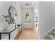 Inviting foyer with light hardwood floors, a decorative mirror, console table and a clear view of the front door at 1912 St John St, Charlotte, NC 28216