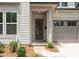 A close-up of a charming front entrance featuring a glass-paneled door, covered porch, and attached one-car garage at 1912 St John St, Charlotte, NC 28216