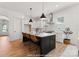 Modern kitchen featuring white cabinets, a black island with seating, and stainless steel appliances at 1912 St John St, Charlotte, NC 28216