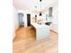 Bright, open kitchen featuring an island with seating, stainless steel appliances, and light wood flooring at 1912 St John St, Charlotte, NC 28216