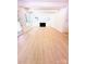 Spacious living room showcasing light wood floors, a modern fireplace, large windows, and white walls at 1912 St John St, Charlotte, NC 28216