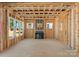 A spacious living room in a new construction, showcasing exposed wood framing and natural light at 1912 St John St, Charlotte, NC 28216