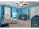 Bedroom with blue walls, crib, rocker, ceiling fan, and plenty of natural light at 2025 Killian Creek Dr, Denver, NC 28037