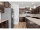 Modern kitchen with stainless steel refrigerator and range and dark wood cabinetry at 2025 Killian Creek Dr, Denver, NC 28037