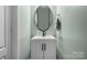 Stylish powder room with a modern vanity, round mirror, and mint green walls at 2025 Killian Creek Dr, Denver, NC 28037