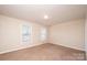 Spacious carpeted bedroom with two windows and neutral walls at 217 22Nd Sw St # H, Hickory, NC 28602