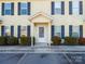 Light yellow siding townhouse with dark shutters, covered entry, and landscaping at 217 22Nd Sw St # H, Hickory, NC 28602