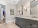 Double vanity bathroom with gray cabinets and herringbone floors at 2223 Croydon Rd # 103, Charlotte, NC 28207