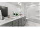 Modern bathroom with double vanity, gray cabinets, and a soaking tub at 2234 Revolution Park Dr, Charlotte, NC 28208