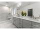 Modern bathroom with double vanity, glass shower, and gray tile flooring at 2234 Revolution Park Dr, Charlotte, NC 28208