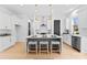 Contemporary kitchen featuring white cabinets, a gray island with seating, and gold lighting at 2234 Revolution Park Dr, Charlotte, NC 28208