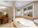 Spa-like bathroom with a soaking tub and large windows overlooking a lake at 237 Wilson Lake Rd, Mooresville, NC 28117