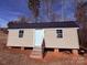 Tan cabin with dark metal roof, white door, and small steps leading to the entrance at 3730 Sedgefield Dr, Conover, NC 28613