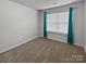 Well-lit bedroom with neutral walls, carpet flooring, and teal curtains at 3758 Yorkshire Pl, Terrell, NC 28682