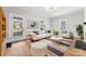 Bright living room featuring hardwood floors, white couches, modern decor, and natural light from the door at 413 W 5Th Ave, Gastonia, NC 28052