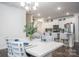 Bright dining area features a modern chandelier and adjacent kitchen with stainless steel appliances and a breakfast bar at 4134 Steel Way, Sherrills Ford, NC 28673