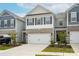 Townhome exterior showcases a well-maintained front yard, a two-car garage, and a combination of siding and stone finishes at 4134 Steel Way, Sherrills Ford, NC 28673