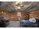 Cozy rustic bedroom featuring wood paneled walls and ceiling, with a comfortable bed and seating area at 4747 Kenneths Dr, Maiden, NC 28650