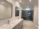 Elegant bathroom with double sinks, modern mirrors, and a glass-enclosed shower with tiled walls at 507 E Lackey Farm Rd, Stony Point, NC 28678