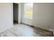 Well-lit bedroom with wood-look flooring, a window, and a closet at 507 E Lackey Farm Rd, Stony Point, NC 28678