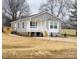 Charming gray home with white trim, a cozy front porch, and a freshly poured concrete driveway at 507 E Lackey Farm Rd, Stony Point, NC 28678