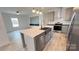 Open kitchen with gray cabinets, stainless steel appliances, island with seating, and modern pendant lighting at 507 E Lackey Farm Rd, Stony Point, NC 28678