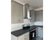 Modern kitchen with gray cabinets, black countertops, stainless steel range hood, and subway tile backsplash at 507 E Lackey Farm Rd, Stony Point, NC 28678