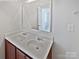 Bathroom with double sink vanity and a large mirror at 6621 Pennacook Dr, Charlotte, NC 28214