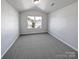 Bright bedroom with gray carpet, a large window and neutral walls at 6621 Pennacook Dr, Charlotte, NC 28214