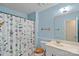 Charming blue bathroom with floral shower curtain, toilet and sink at 709 Falls Church Rd, Charlotte, NC 28270