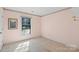 This carpeted bedroom has light pink walls, and a window that allows natural light to fill the space at 709 Falls Church Rd, Charlotte, NC 28270